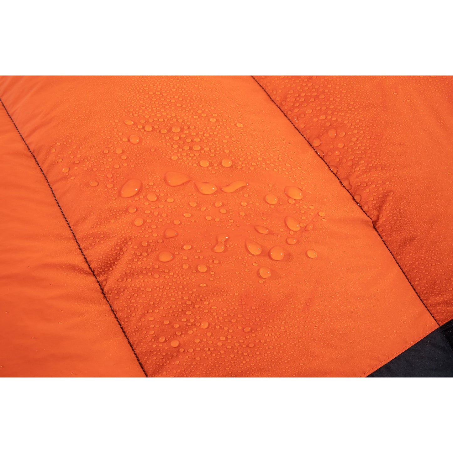 Water droplets beading on the black shell of a QEZER down sleeping bag