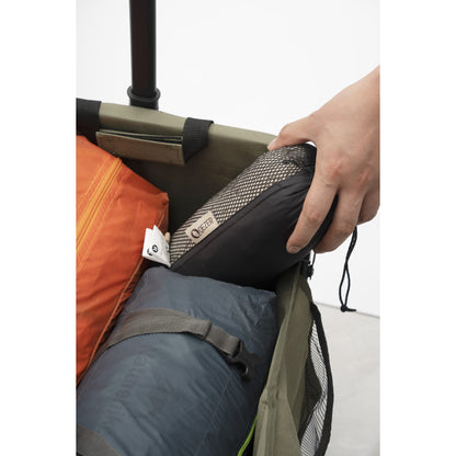 Compact QEZER sleeping bag liner stored with camping gear in a folding wagon