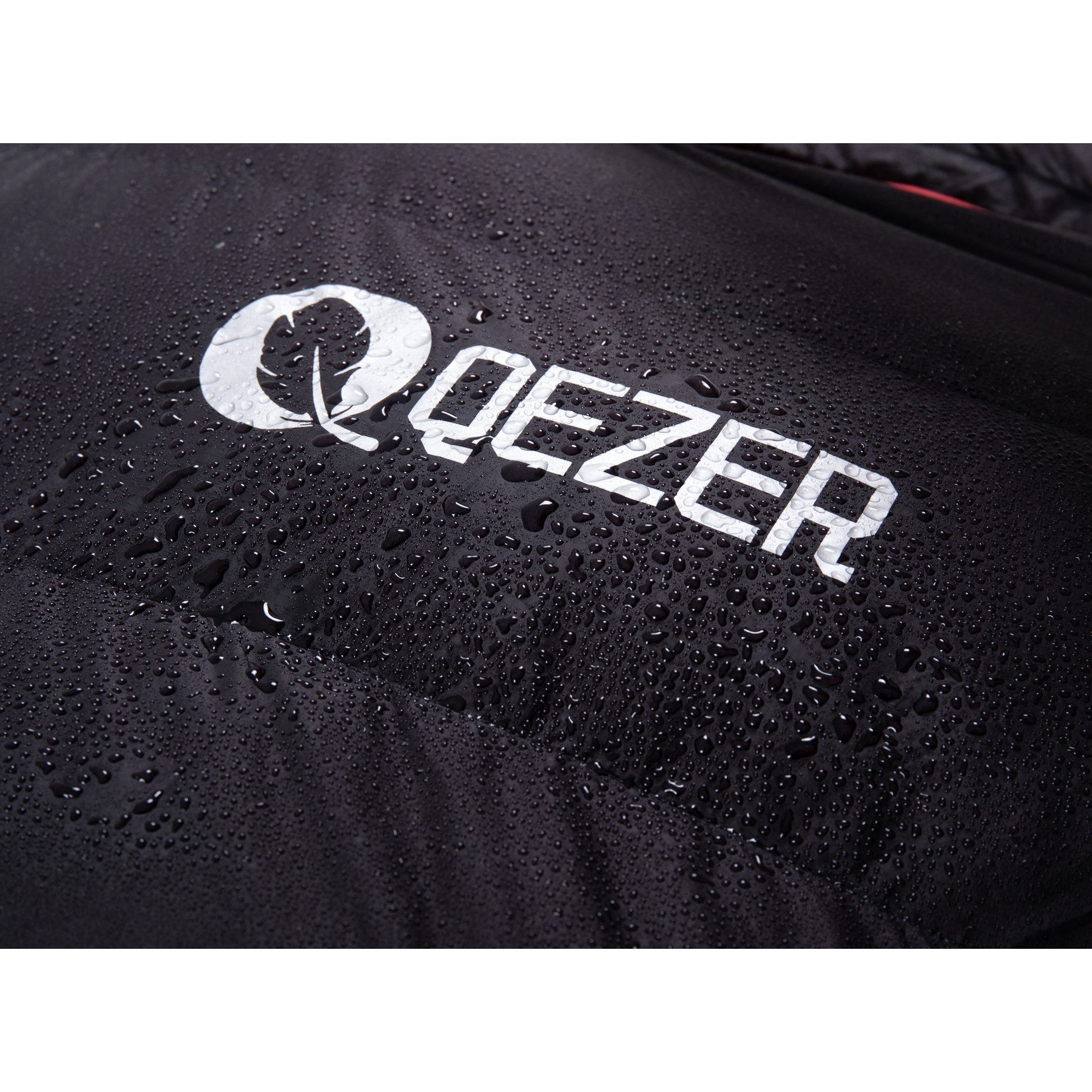 Water droplets beading on the black waterproof shell of a QEZER down sleeping bag